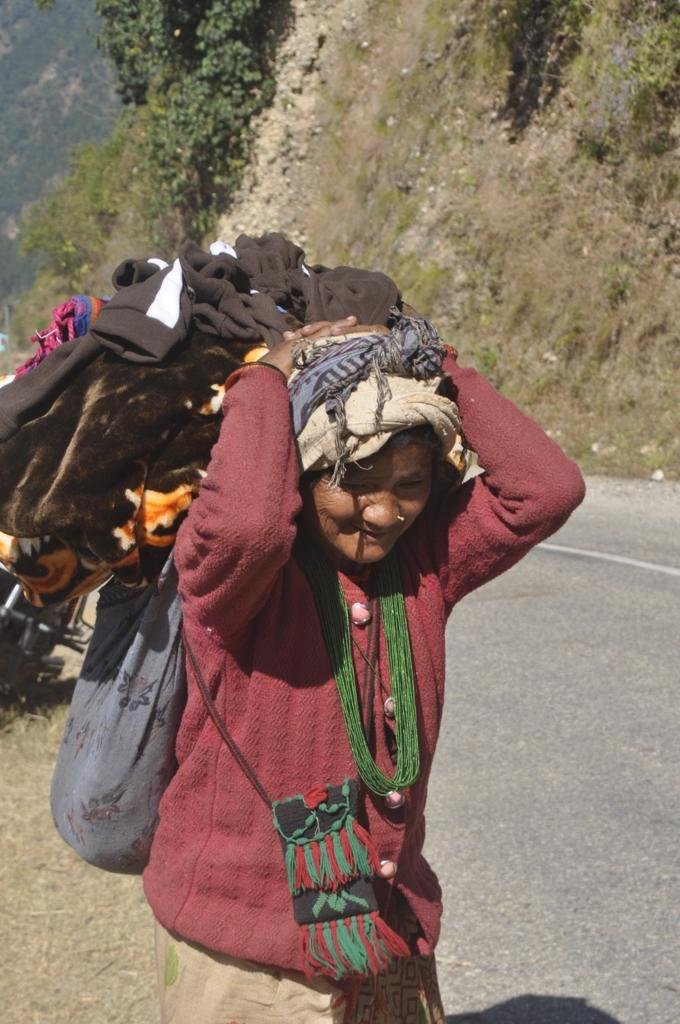 Mujer llevando las cobijas recibidas a su hogar